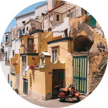 Scooter in de straten van het Italiaanse eiland Procida met de gekleurde traditionele huisjes van Michiel Dros