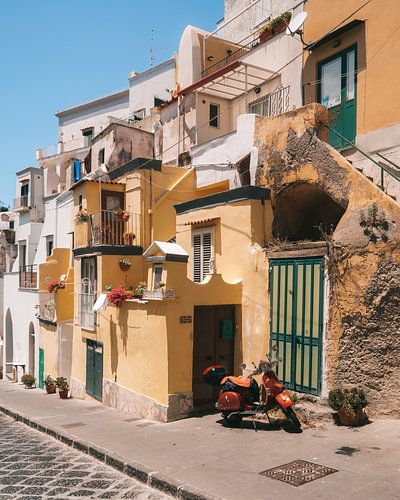 Scooter in de straten van het Italiaanse eiland Procida met de gekleurde traditionele huisjes