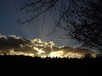 Zonnestralen door de wolken