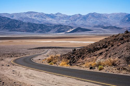 Kurvenreiche Asphaltstraße mit gelbem Streifen im Death Valley