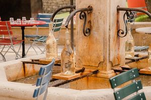 Französische, farbenfrohe Terrasse rund um einen Springbrunnen