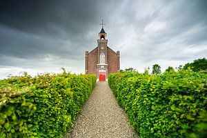 Petite église historique en briques avec une allée de jardin symétrique