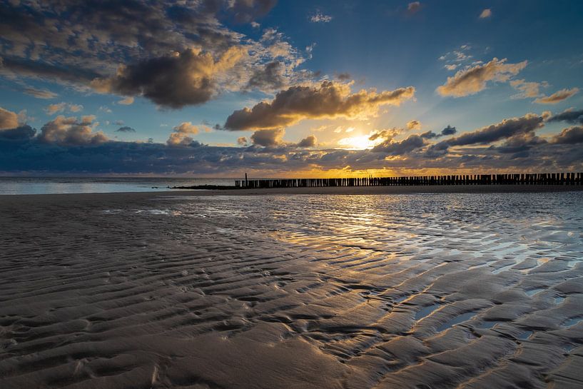 spectacular sunset on the Zeeland beach with the typical Dutch breakwaters by Kim Willems