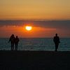 Wandelen op het strand met zonsondergang van Miranda Zwijgers