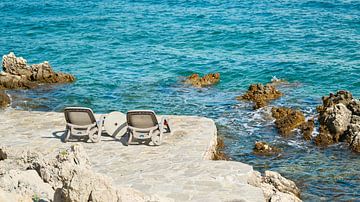 Twee ligstoelen aan de rotsachtige kust bij Krk