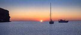Adembenemende zonsopgang boven Cala Joncols met rustige bootjes in Co van PhotoCluster