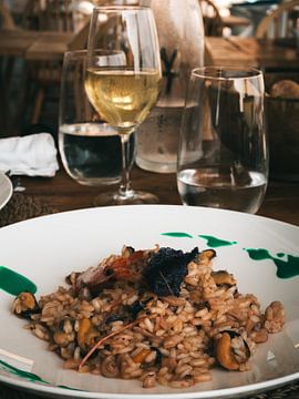 Verse seafood risotto met een glas Italiaanse wijn op het eiland Procida in Italië