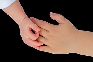 Hand van baby met hand van kind