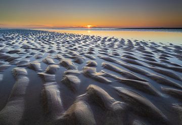 Zandheuvels bij zonsondergang aan de kust