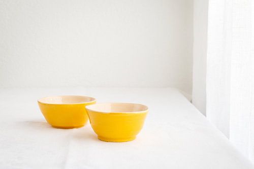 Stilleven met twee gele aardewerken schaaltjes