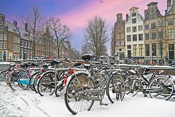 Besneeuwde fietsen in Amsterdam Nederland in de winter bij zonsondergang van Eye on You