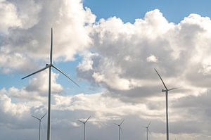 Windkraftanlagen mit blauem Himmel und weißen Wolken im Hintergrund