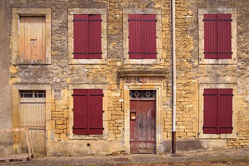 Weathered facade with red shutters