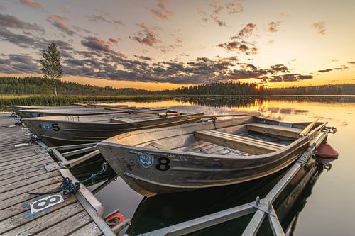Bateaux à rames sur une jetée dans un lac en Suède