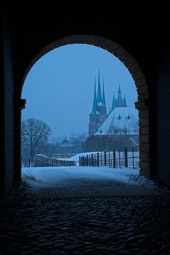 View through the portal of the citadel on Petersberg hill towards the cathedral and Severi Church in Erfurt in winter