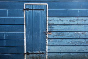 Pignon en bois vieilli bleu-blanc avec porte fermée sur Blond Beeld