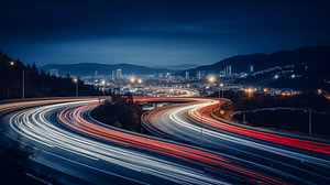 Zeitraffer-Autolichtspuren auf der nächtlichen Stadtstraße mit Skyline im Hintergrund