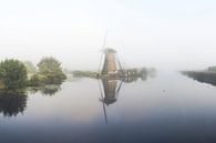 Kinderdijk windmolen in mist van Jasper Verolme thumbnail