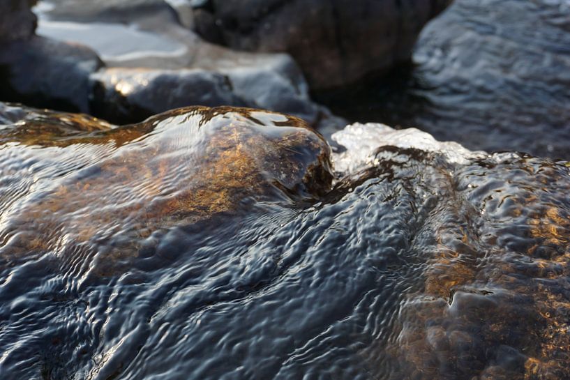 Stones in clear flowing water by Travelled4u