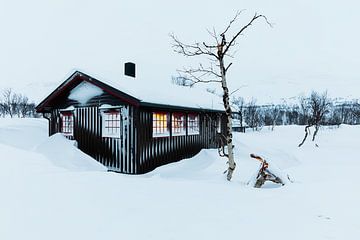 Houten huis in de sneeuw