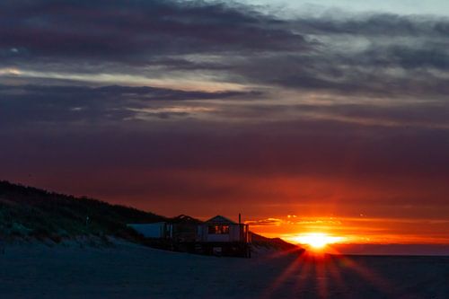 Afgelegen strandhuis met uitzicht op zee bij zonsondergang