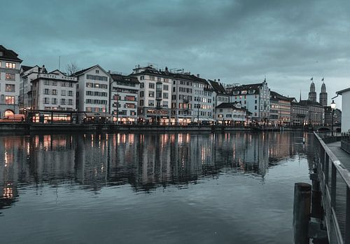 Zicht op de oude binnenstad van Zürich en de Grossmünster kerk weerspiegeld in de Limmat rivier