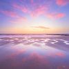Ein Himmel voller Abendrot spiegelt sich auf dem nassen Sand des Strandes. von Bas Meelker