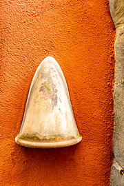 Lampshade against an orange-coloured house wall by Dieter Walther
