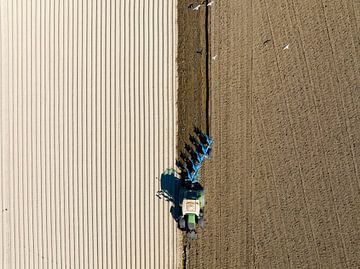 Tractor preparing the soil for planting crops seen from above by Sjoerd van der Wal