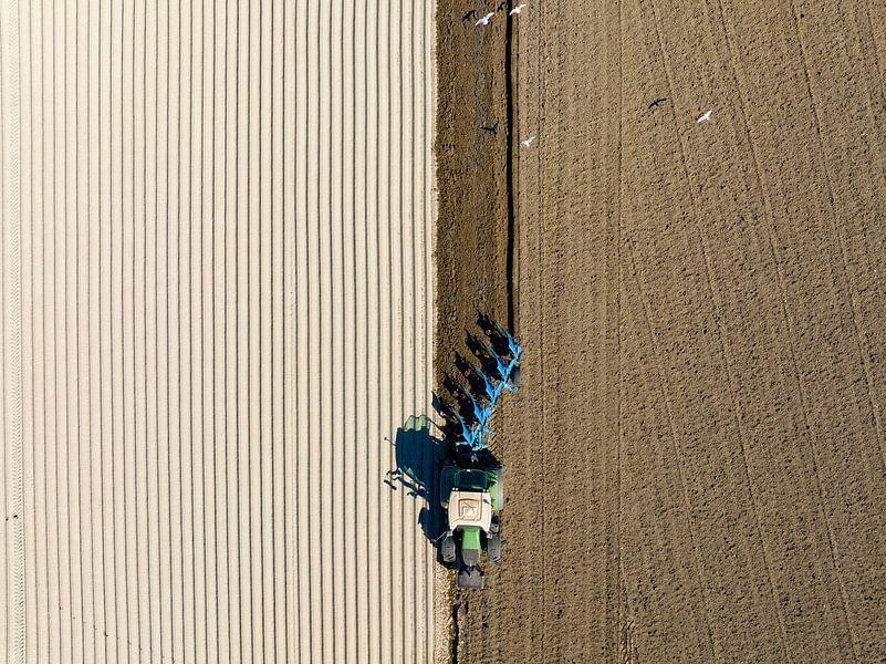 Tractor maakt de grond klaar voor het planten van gewassen van bovenaf van Sjoerd van der Wal Fotografie