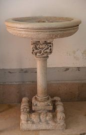 Antique baptismal font in church Chiesa di San Francesco d'Assisi in Matera, Italy by Joost Adriaanse
