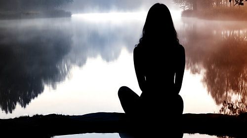 Yoga op een mistig meer bij zonsopgang