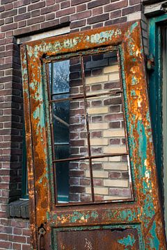 Eine alte Werkstatttür hängt im Rahmen. von Zaankanteropavontuur