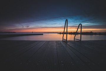 Open lucht zwembad aan recreatieplas tijdens zonsondergang