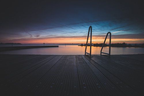 Open lucht zwembad aan recreatieplas tijdens zonsondergang