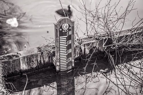 Waterpeilmeter in poldersloot en houten dam in vintage kleur