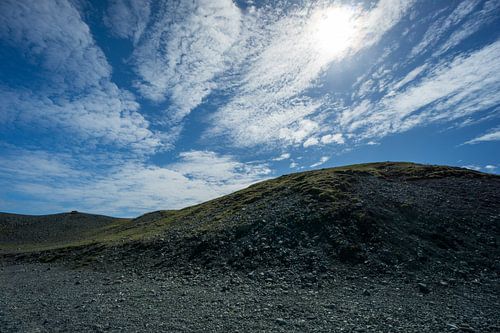 Islande - Collines de pierre noire couvertes d'herbe verte et ciel bleu