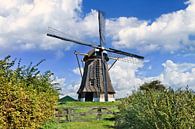 Nederlandse traditionele windmolen in een weide, blauwe lucht en de wolken 1 van Tony Vingerhoets thumbnail