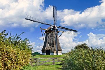 Nederlandse traditionele windmolen in een weide, blauwe lucht en de wolken 1 van Tony Vingerhoets