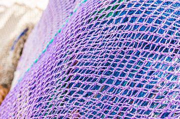 Close-up of purple and blue fish net heap, maritime background texture by Alex Winter