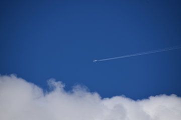 Een vliegtuig vliegt door een blauwe hemel van Claude Laprise