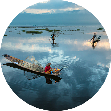 Visser die met traditionele boot op het Inle meer in Myanmar op ouderwetse wijze met een vis korf vi van Wout Kok