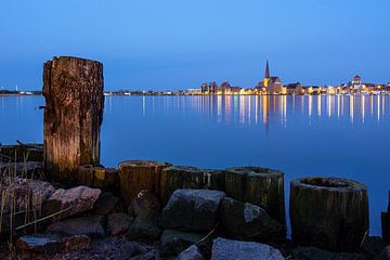 Uitzicht over de Warnow rivier naar de stad Rostock 's avonds van Rico Ködder