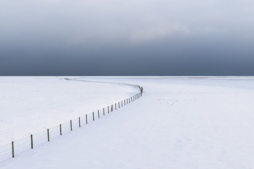 Un paysage hivernal vide et enneigé dans le parc national de Lauwersmeer. À l'horizon, de sombres nu par Bas Meelker