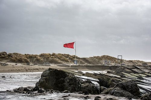 De stormvlag waait op de Zuid pier IJmuiden.