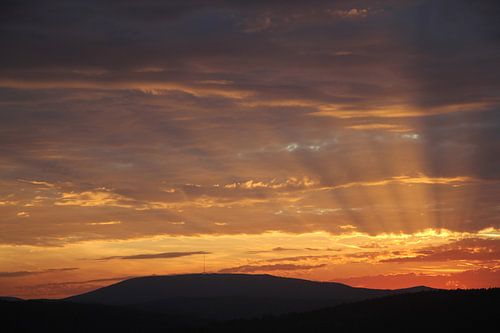 Zonsondergang met stralen in de richting van Kreuzberg