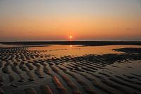 Orange sunset on beach with sand ridges