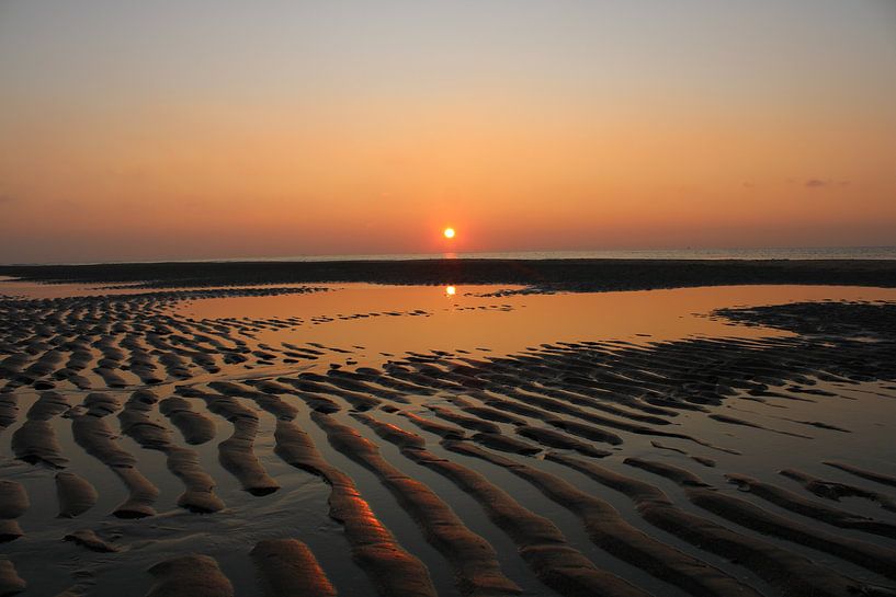 Coucher de soleil orange sur une plage avec des crêtes de sable par Karin Cijsouw