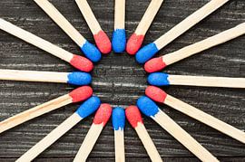 Red and blue matches on black background by Wijnand Loven