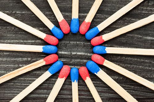 Rode en blauwe lucifers in cirkel op zwarte achtergrond
